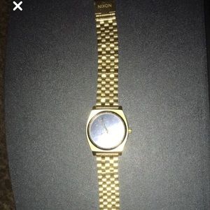 Round gold analog nixon watch